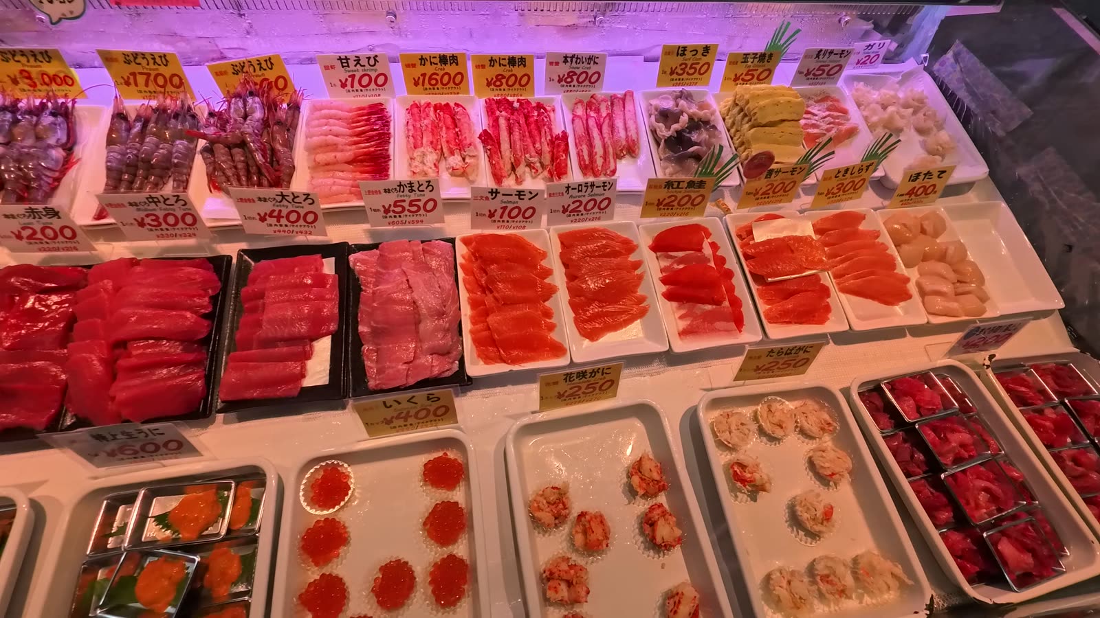 Trays of tuna, salmon, salmon roe and scallops with price tags at Washo Market